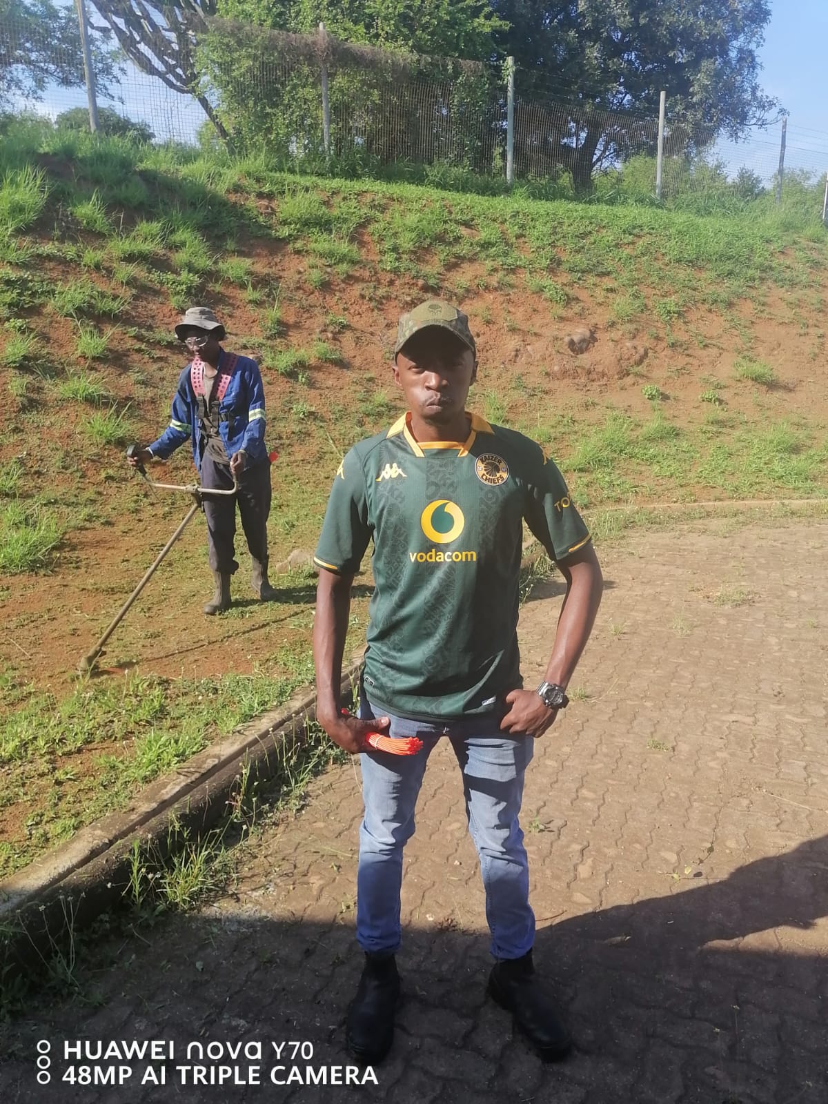 Team members beside a freshly cut grass embankment