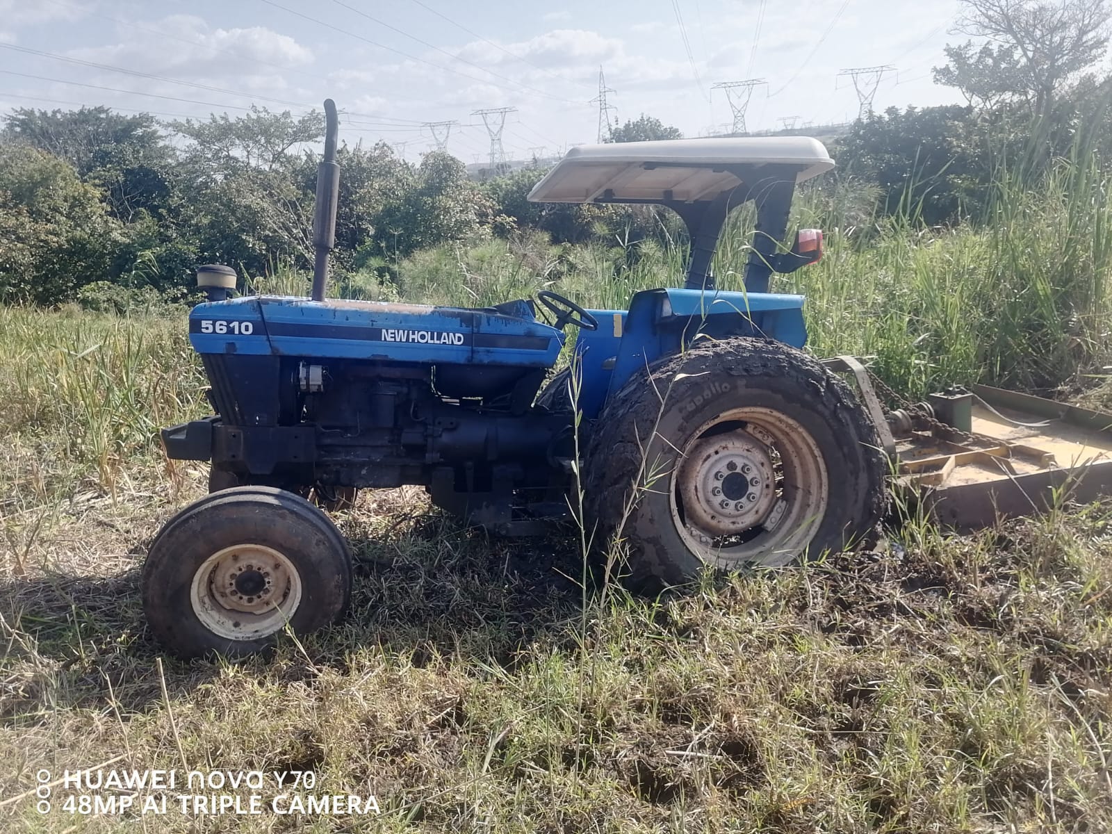 Tractor working through tall vegetation on a large property